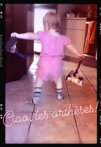 Malou, de dos, qui s'éloigne de la caméra. Elle semble dire "Ciao!" à ses orthèses (en fait la photo date de quelques semaines mais vous comprenez le principe!)